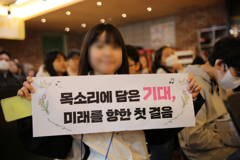 KYF뮤즈 청소년합창단 발대식에서 합창단원이 플랜카드를 들고 있다