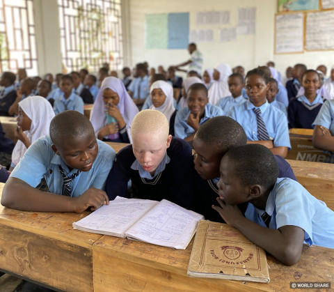 학교 수업시간에 시력이 좋지 않은 알비노 학생을 일반 학생들이 도와주고 있다